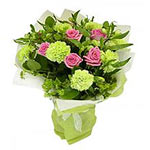 A classic presentation of pink roses and green carantions arranged with green bl...