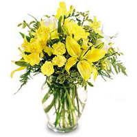 Yellow lilies, yellow freesia, and yellow alstroemeria surround delicate white r...