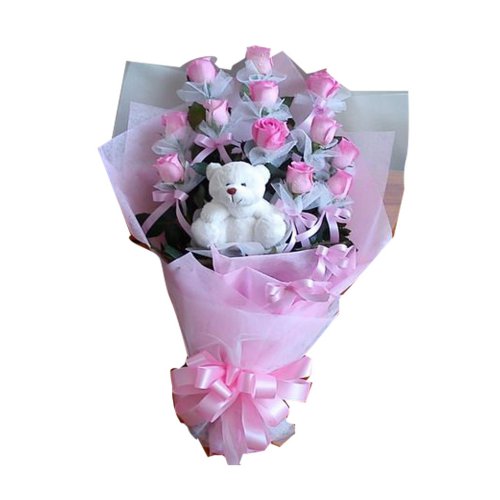 A beautiful pink rose bouquet sits on a bed of tro...