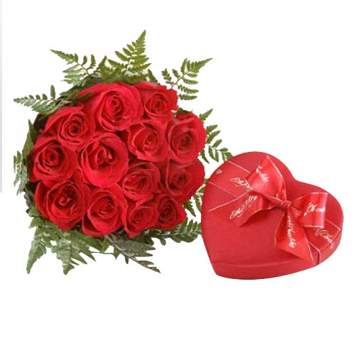 One dozen red roses in a bouquet with heart shape ...