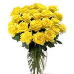 A beautiful glass vase arrangement of yellow roses, decorated beautifully with l...